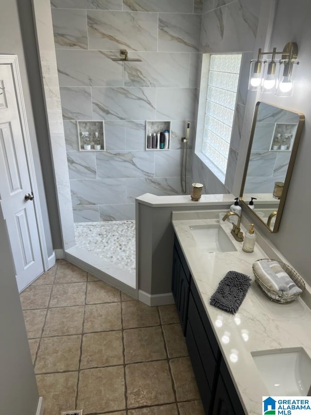 bathroom with tiled shower and vanity