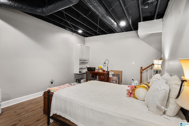 bedroom with dark hardwood / wood-style floors