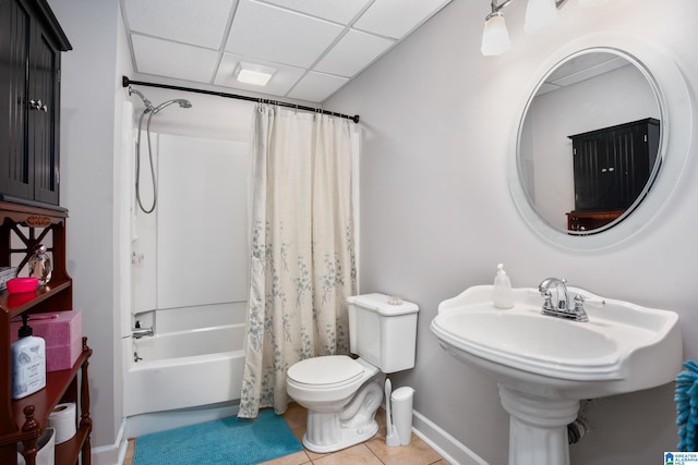 full bathroom with sink, shower / bath combination with curtain, tile patterned flooring, toilet, and a drop ceiling