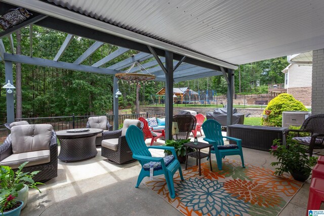 view of patio featuring a trampoline and an outdoor living space with a fire pit