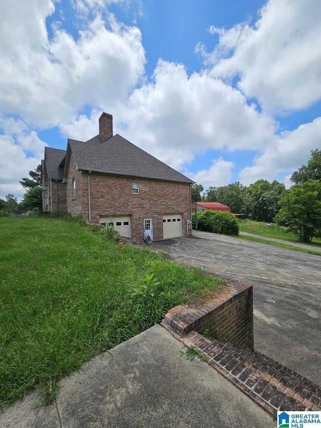 view of side of home with a yard and a garage