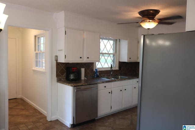 kitchen with fridge, sink, stainless steel dishwasher, tasteful backsplash, and white cabinetry