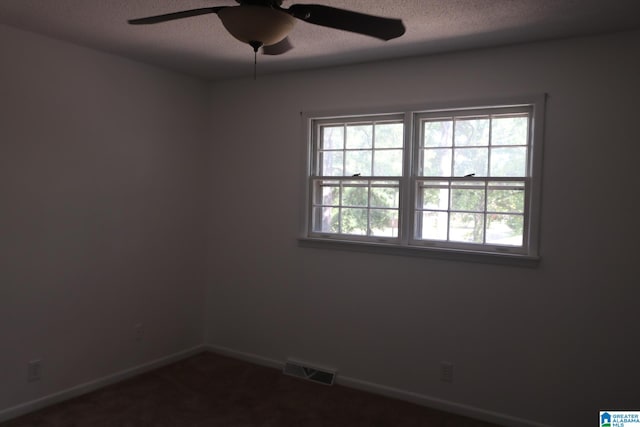 unfurnished room featuring a textured ceiling, carpet floors, and ceiling fan