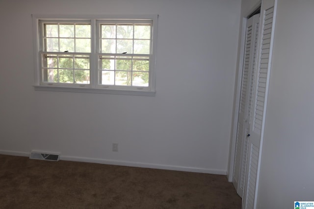 unfurnished bedroom featuring dark colored carpet