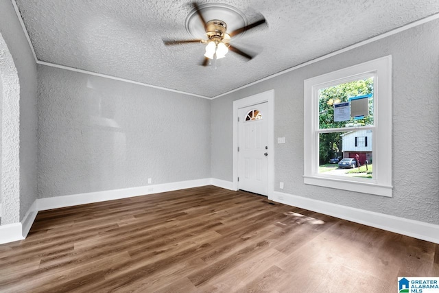 interior space with hardwood / wood-style floors, ceiling fan, and ornamental molding