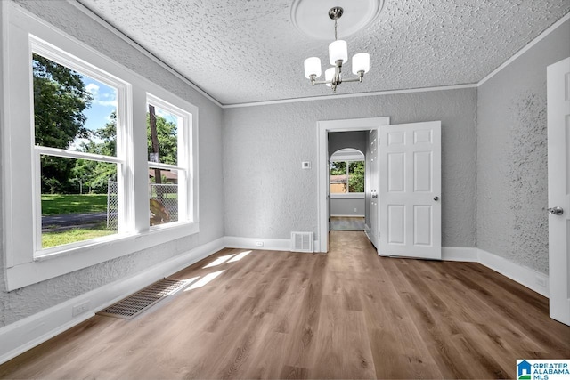 unfurnished dining area with hardwood / wood-style flooring, a notable chandelier, and crown molding