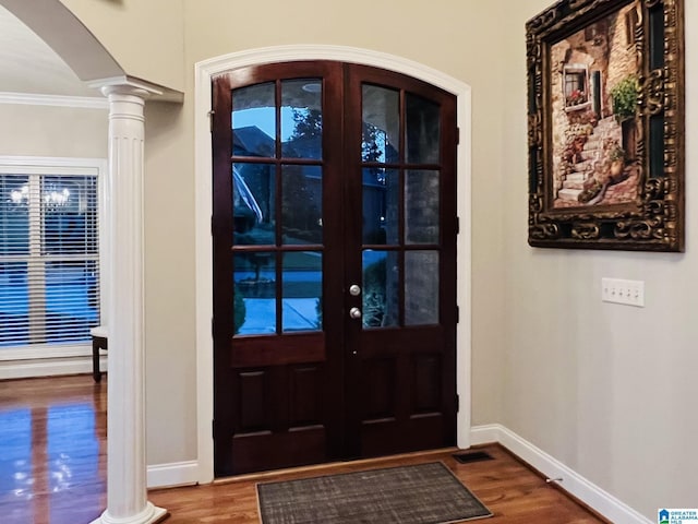 entryway featuring french doors, hardwood / wood-style flooring, decorative columns, and crown molding