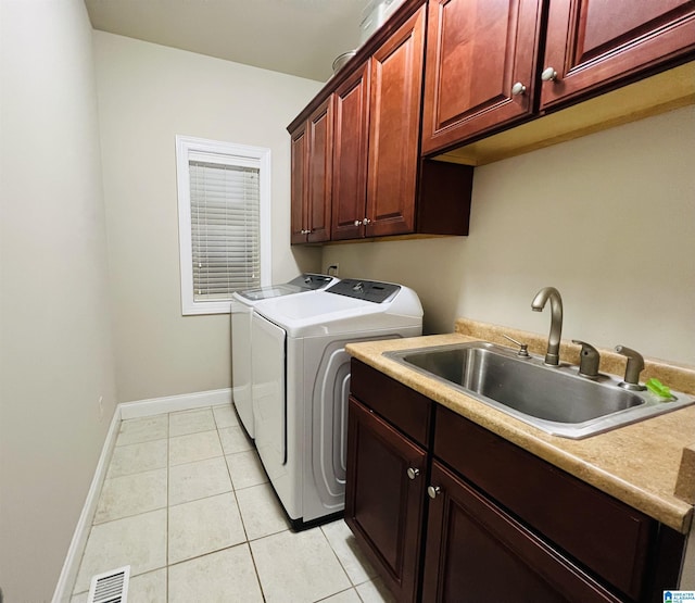 laundry room featuring light tile patterned flooring, cabinets, separate washer and dryer, and sink