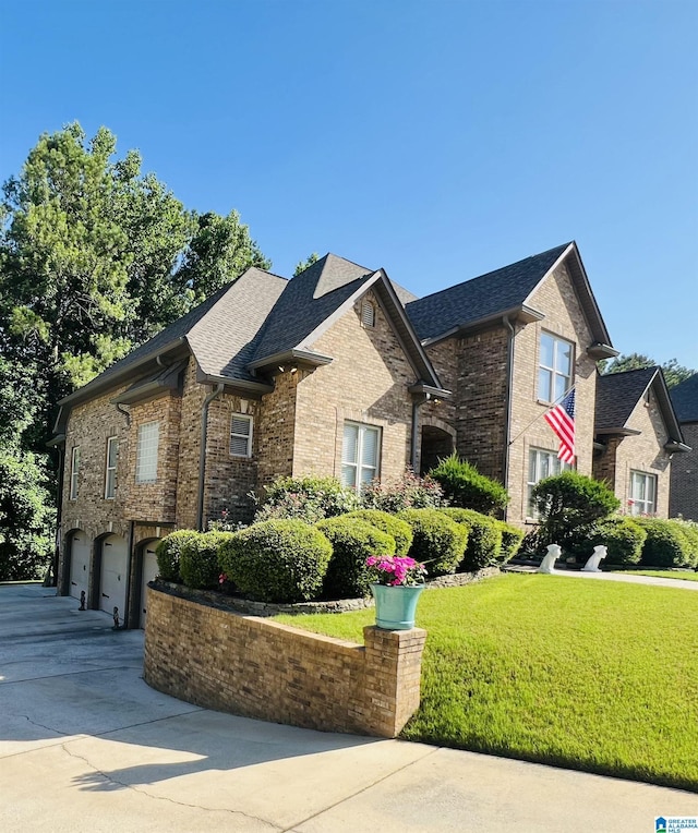 view of side of property featuring a lawn and a garage