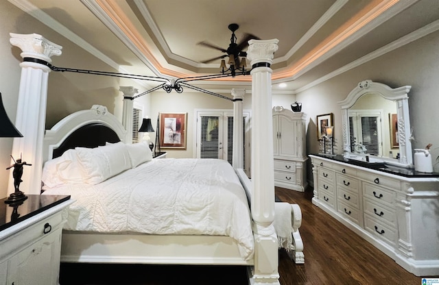 bedroom featuring a raised ceiling, dark hardwood / wood-style flooring, crown molding, and decorative columns