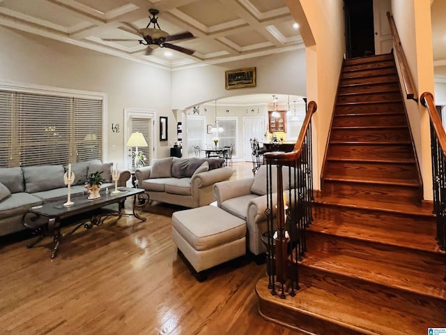 living room with hardwood / wood-style floors, ornamental molding, ceiling fan, and coffered ceiling