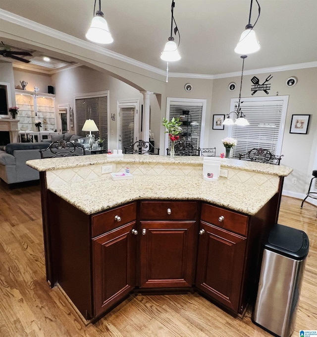 kitchen featuring pendant lighting, light hardwood / wood-style flooring, and ornamental molding