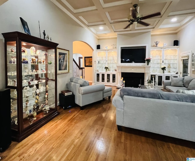 living room featuring ceiling fan, ornamental molding, coffered ceiling, and hardwood / wood-style flooring