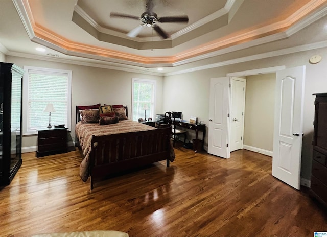 bedroom with a tray ceiling, crown molding, ceiling fan, and dark hardwood / wood-style floors