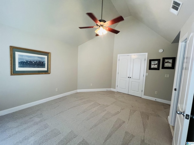 unfurnished bedroom featuring ceiling fan, a closet, high vaulted ceiling, and light carpet