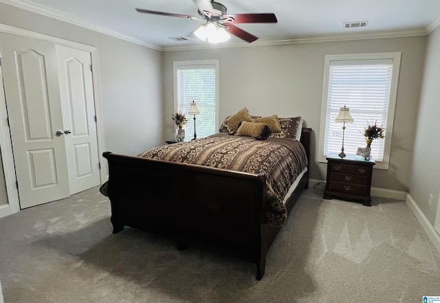 carpeted bedroom featuring ceiling fan, a closet, and ornamental molding