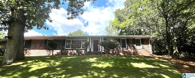 single story home with entry steps, a front lawn, and brick siding