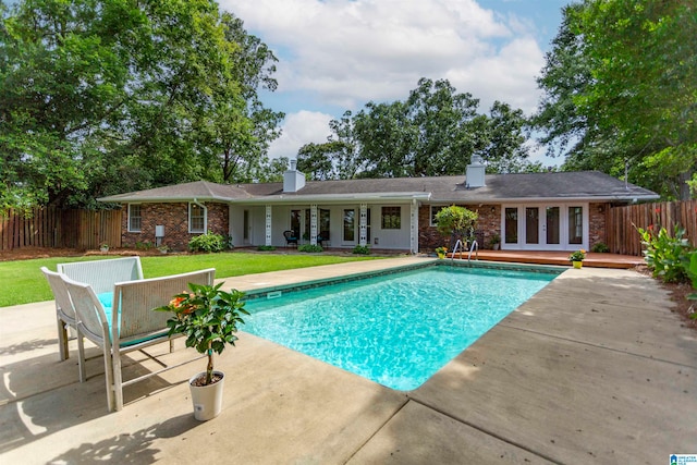 view of swimming pool featuring a patio and a lawn