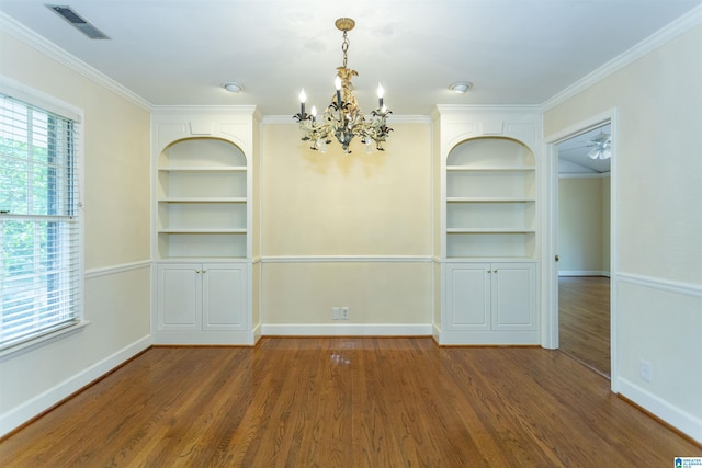 unfurnished dining area featuring built in features, visible vents, dark wood-type flooring, and a wealth of natural light