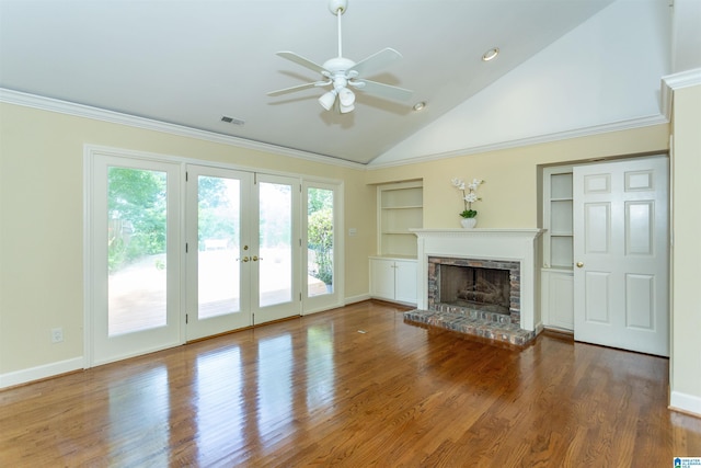 unfurnished living room featuring built in shelves, visible vents, a fireplace, and wood finished floors