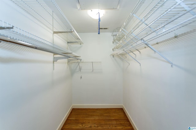 spacious closet with attic access and wood finished floors