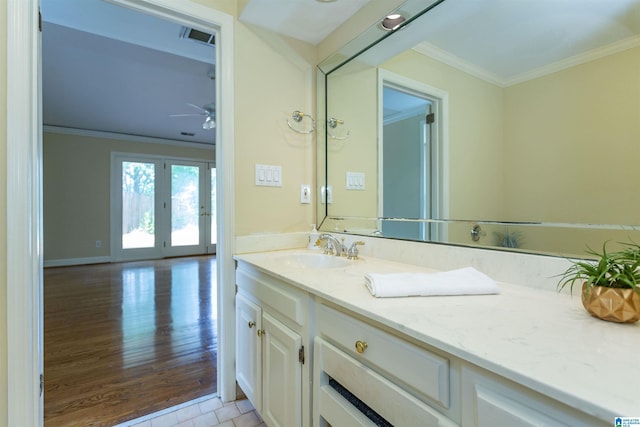 bathroom with visible vents, wood finished floors, vanity, and crown molding