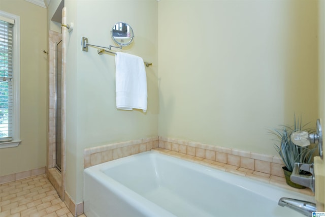 bathroom with baseboards, a shower with shower door, a washtub, and tile patterned floors