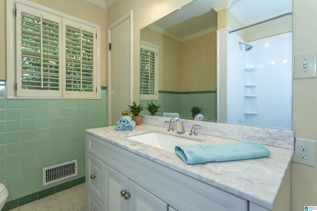 bathroom featuring tile patterned flooring, vanity, visible vents, tile walls, and crown molding