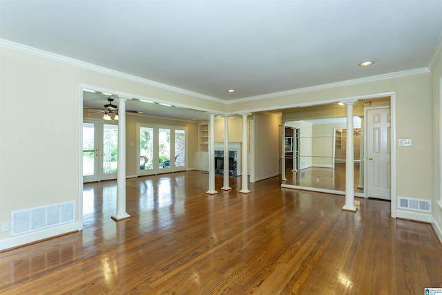 unfurnished living room with dark wood finished floors, visible vents, and decorative columns