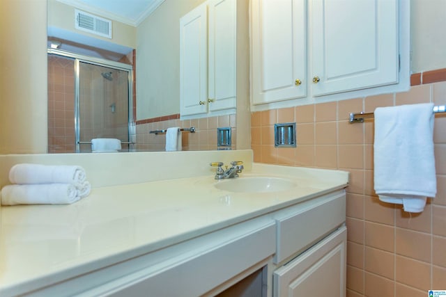 bathroom featuring tasteful backsplash, crown molding, oversized vanity, and tile walls