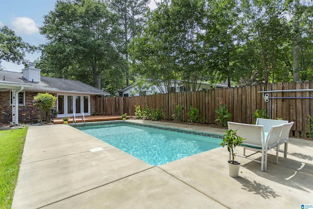 view of pool with french doors, a patio area, a fenced backyard, and a fenced in pool