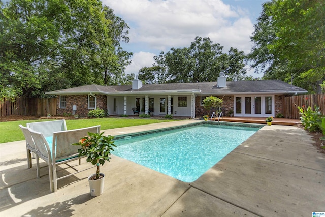 view of swimming pool featuring a fenced in pool, french doors, a yard, a patio area, and fence