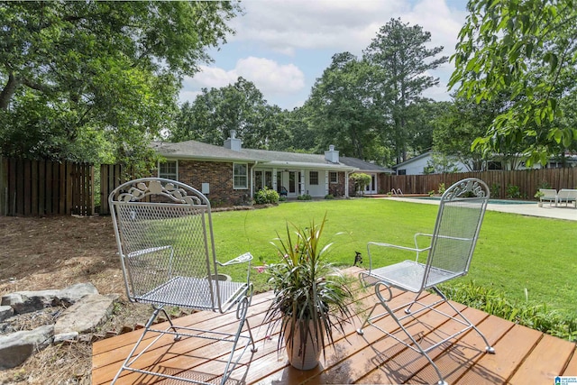 exterior space with brick siding, fence, a chimney, and a lawn