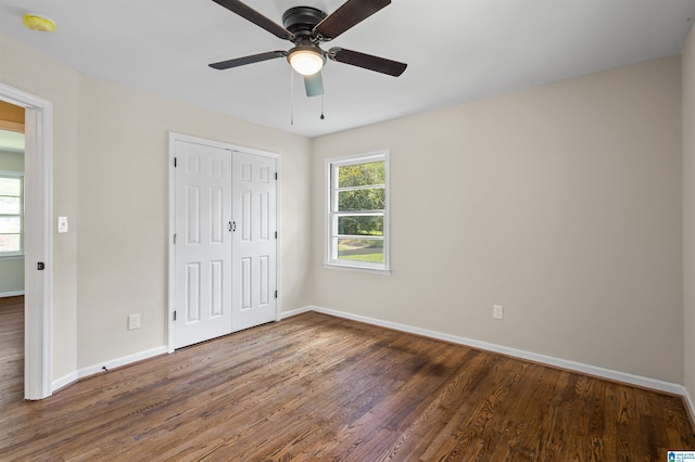 unfurnished bedroom featuring ceiling fan, dark wood-type flooring, and a closet