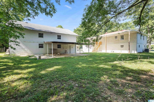 back of house with a patio and a lawn