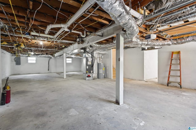 basement featuring electric panel, electric water heater, and heating unit