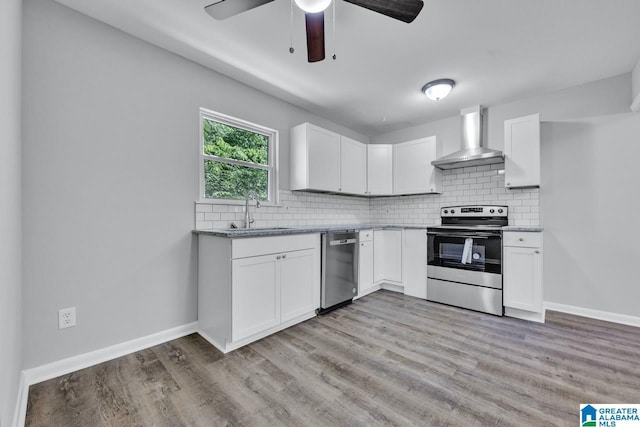 kitchen with white cabinets, wall chimney exhaust hood, sink, and appliances with stainless steel finishes