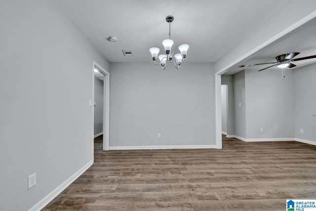 spare room featuring ceiling fan with notable chandelier and hardwood / wood-style flooring