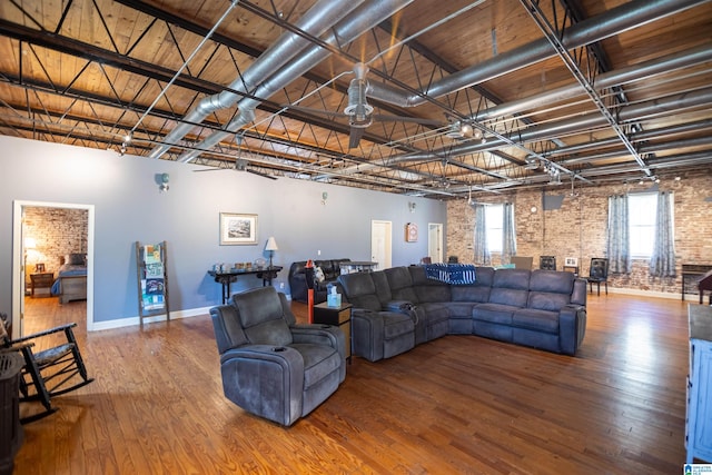 living room featuring wood-type flooring and brick wall