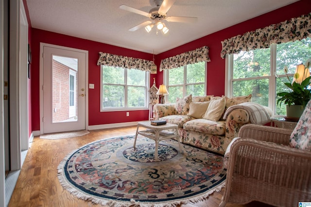 living room featuring plenty of natural light, ceiling fan, light hardwood / wood-style floors, and a textured ceiling