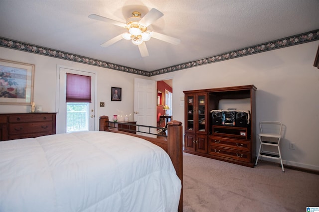 carpeted bedroom with ceiling fan and a textured ceiling