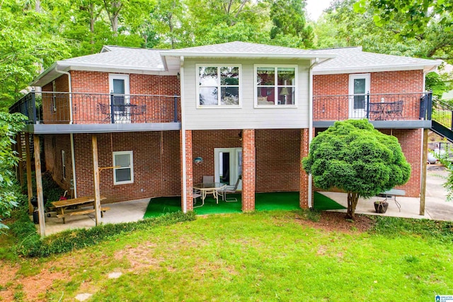 rear view of house with a patio and a lawn