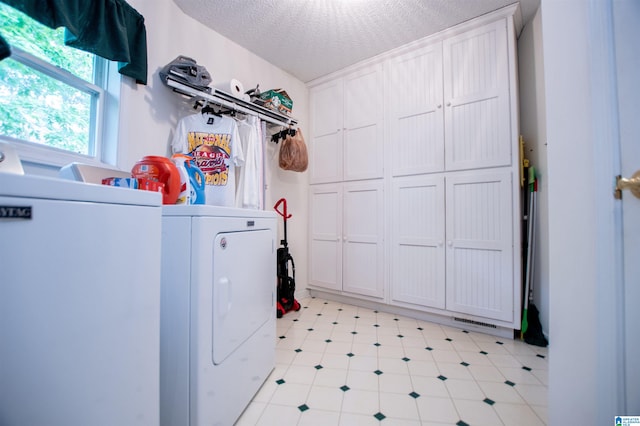 laundry room featuring a textured ceiling, washer / dryer, and light tile floors