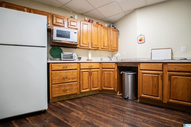 kitchen with dark hardwood / wood-style floors, white appliances, and a paneled ceiling