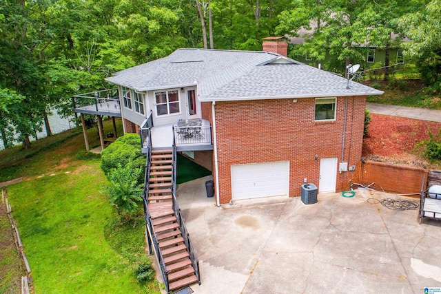 rear view of house with a patio, a garage, a deck, and central air condition unit