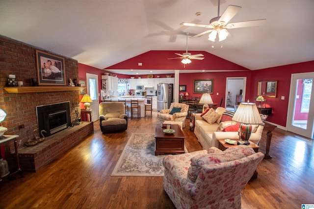 living room featuring a fireplace, wood-type flooring, ceiling fan, and vaulted ceiling