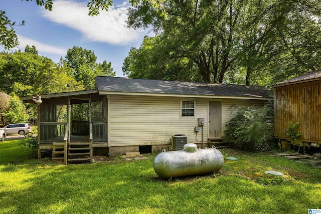 rear view of house with a lawn and a sunroom