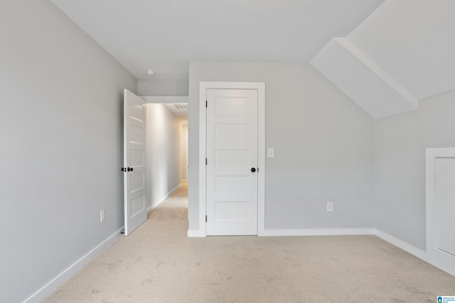 additional living space with light carpet and vaulted ceiling