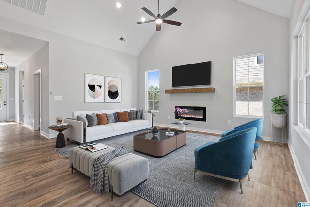 living room featuring high vaulted ceiling, a healthy amount of sunlight, and hardwood / wood-style flooring