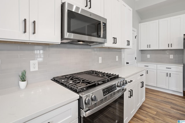 kitchen featuring tasteful backsplash, hardwood / wood-style flooring, stainless steel appliances, and white cabinetry